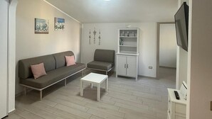 A spacious living area with a sofa, a small table, and a cabinet.