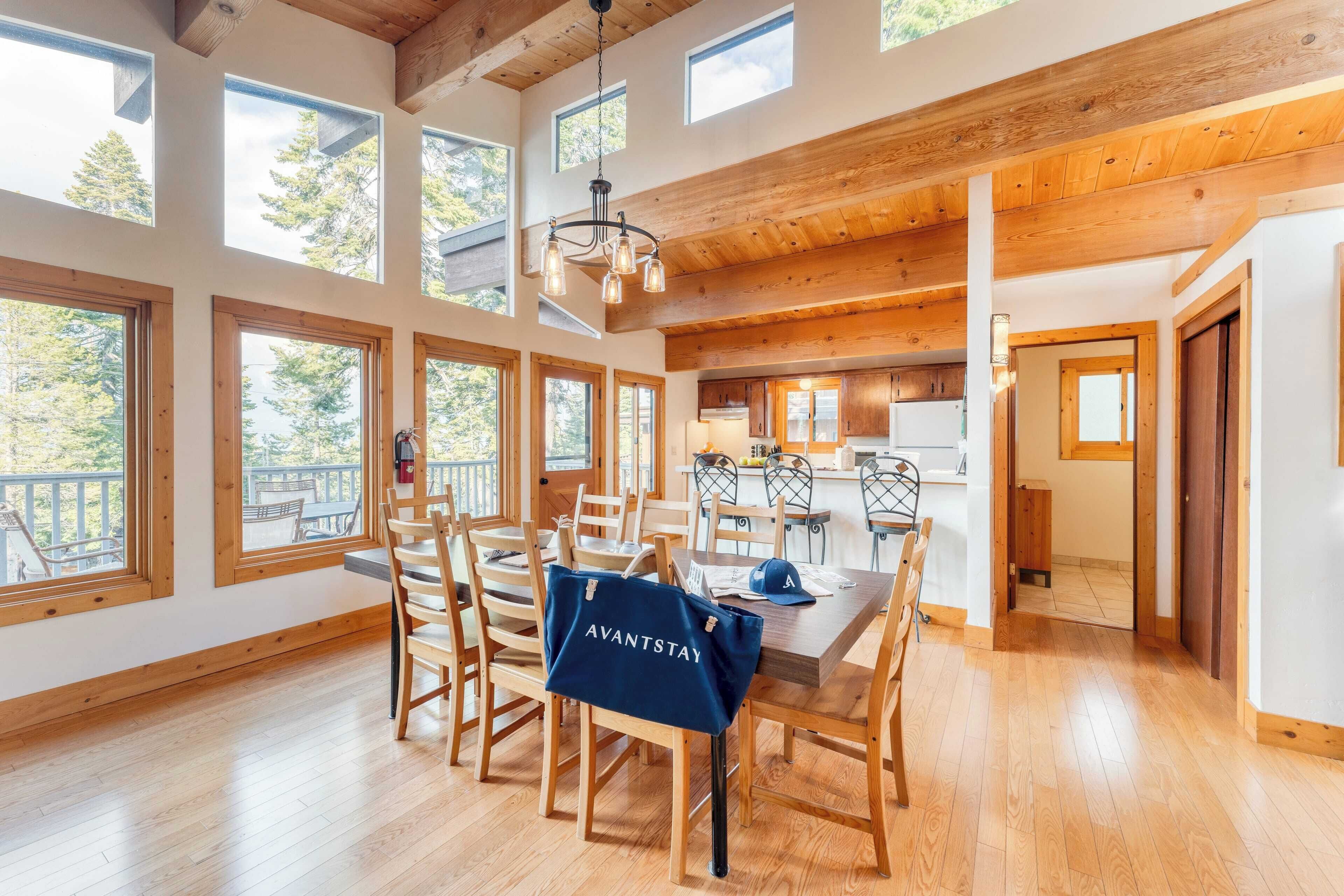 A spacious dining area with wooden tables and chairs, large windows, and a view of the outdoors.