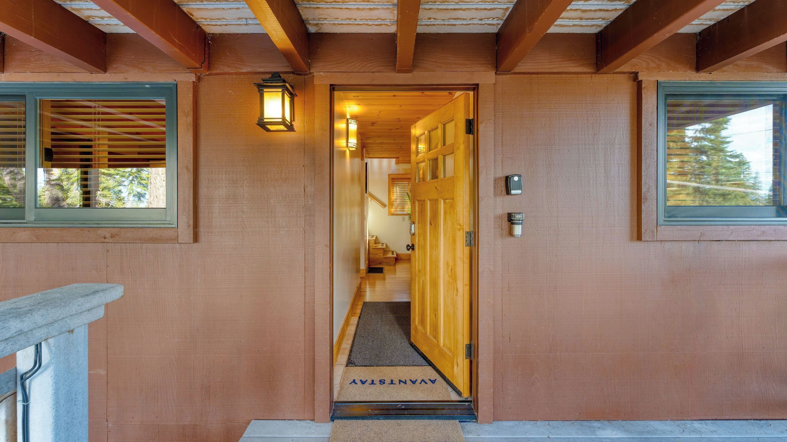 A wooden exterior with a door leading to a staircase.