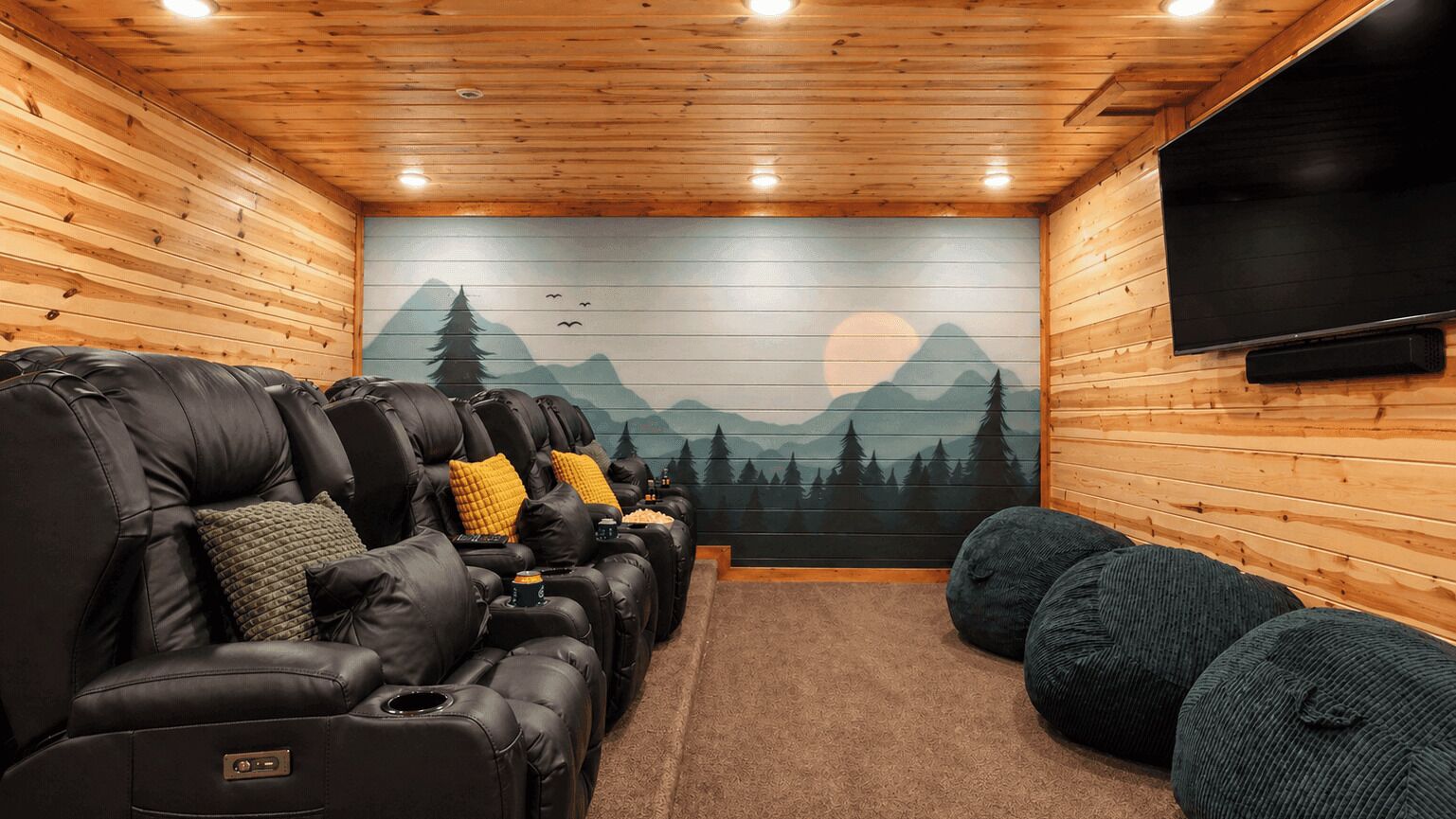 A cozy room with a fireplace, a large TV, and a mural of mountains.