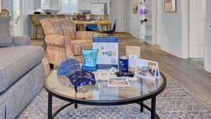 A living room with a round glass coffee table displaying various items. - Ion by Avantstay Walk to Beach, Dining, Shopping Central Location Deck (Sullivan's Island)