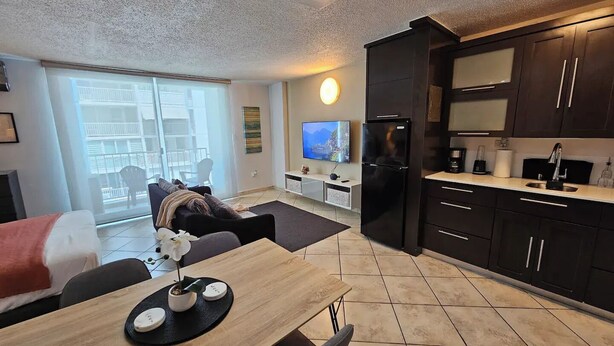 Un appartement moderne comprenant un coin repas, une cuisine et un balcon avec vue.