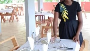 Un espace extérieur abrité, aménagé pour les repas, avec des tables dressées, des nappes blanches et des chaises en bois.