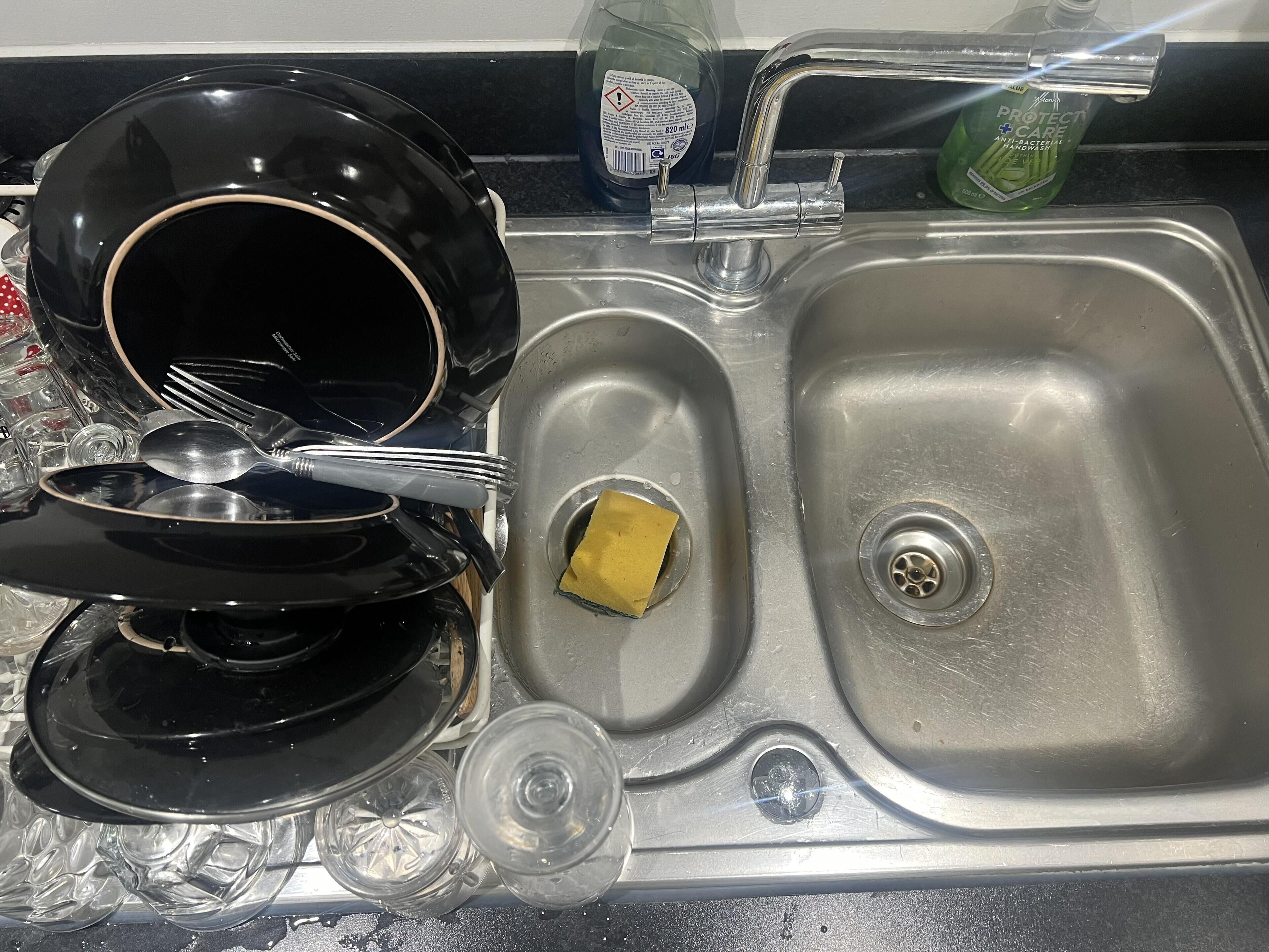 Ein Spülbecken aus Edelstahl mit einer Flasche Spülmittel und einem Schwamm.