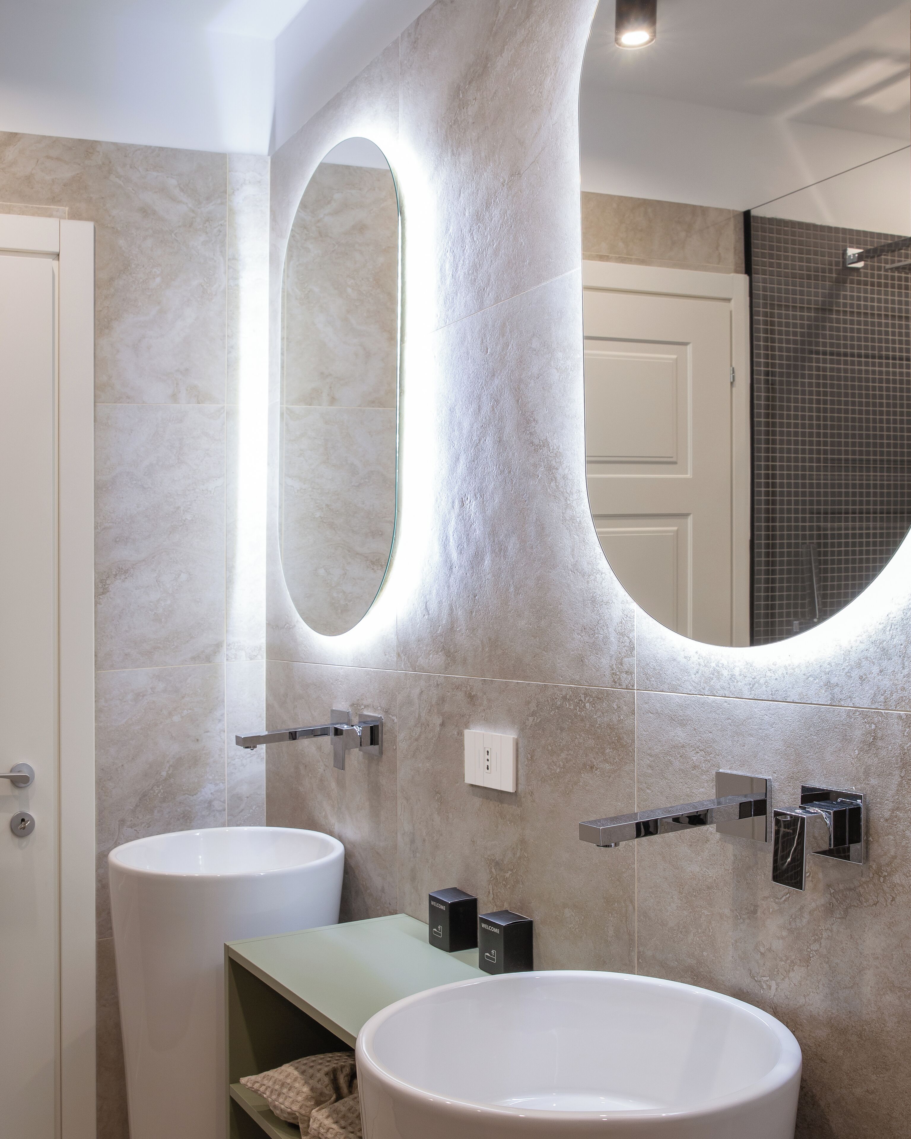 A bathroom with two sinks, a mirror, and a shower.