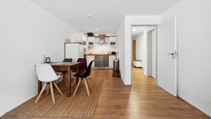 Une cuisine moderne avec des armoires blanches, des appareils en acier inoxydable et un plan de travail en bois.