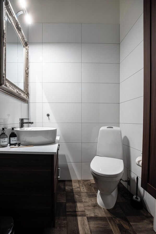 A modern bathroom with a white sink, mirror, and toilet. - Spacious Oasis Only Minutes From the City Center (Stockholm)