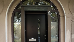 En sort dør med nummeret '4' over, placeret i en buet indgang.