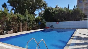 En rektangulär swimmingpool med blått kakel på insidan, omgiven av en plattlagd yta.
