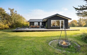 A modern house with a deck, outdoor seating, and a fire pit. - 6 bedroom beach front home in Løgstør (Løgstør)