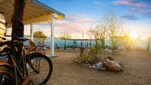 A covered outdoor area with a bicycle, a table, and a rustic setting.