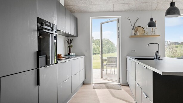 A modern kitchen with stainless steel appliances, a large window, and a view of the outdoors. - Awesome home in Haderslev with sauna (Haderslev)