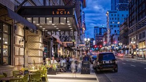A hotel named 'Hotel Lucia' with outdoor seating and a visible entrance.