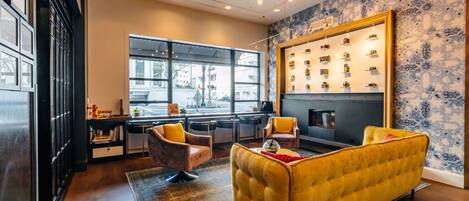 A modern interior with a yellow sofa, a fireplace, and a display of cameras.