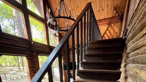 Eine Holztreppe mit Metallgeländer führt zu einer Terrasse.