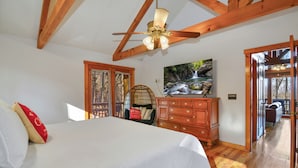 Un dormitorio con cama, cómoda de madera y ventilador de techo.