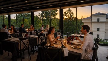 An outdoor dining area with tables, chairs, and guests.