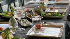 A dining table set with plates, glasses, and a small vase with greenery. - The Reference Club Restaurant & Accommodation (Luleburgaz)