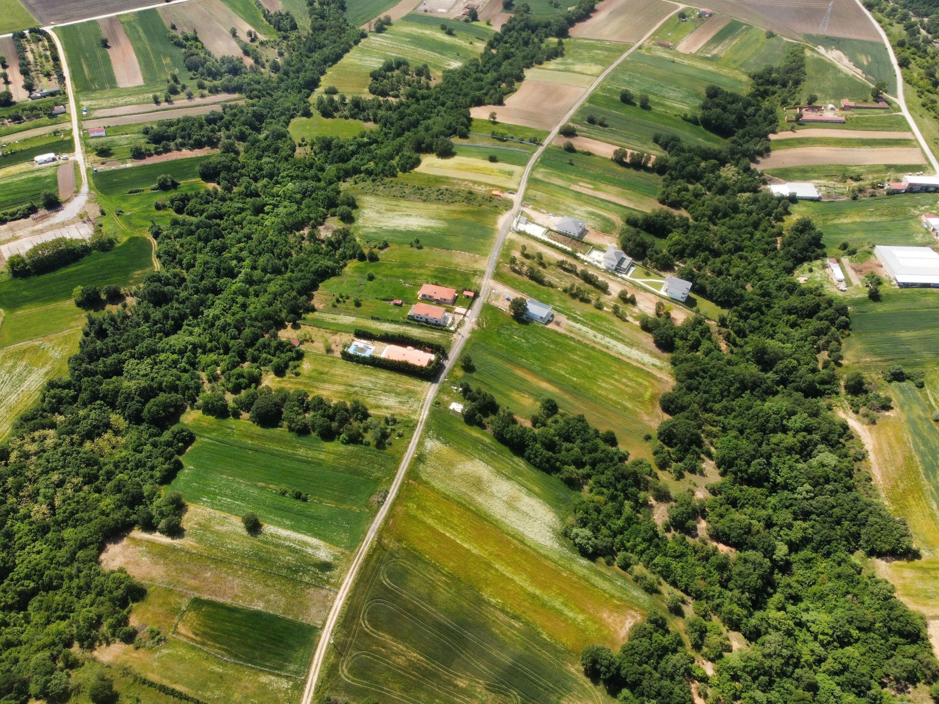 An aerial view of a rural area with fields, roads, and scattered buildings.