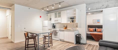 Departamento urbano, vista a la ciudad | Cocina privada | Refrigerador con congelador, microondas y parrilla de estufa