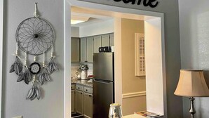 Una cocina con un cartel de 'welcome', una decoración de atrapasueños y una lámpara.
