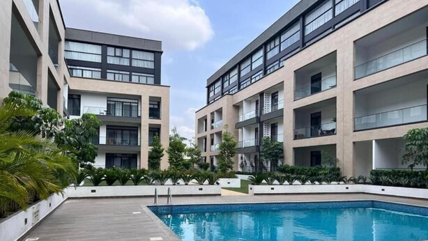 A modern building with multiple balconies, a swimming pool, and landscaped areas with plants. - Embassy garden ebs legend luxury studio  (Accra)
