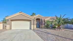 A single-story house with a beige facade, a white garage door, and a number '9020' on the door.