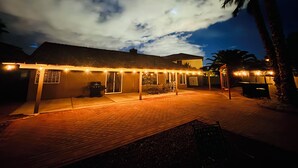A building with a covered patio area, outdoor seating, and a view of the sky.