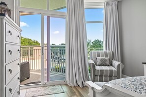 A bedroom with a large sliding glass door to a balcony, a bed, a chair, and a dresser. - Horizon at 77th Condo ~ sleeps 8 ~ 2B/2B ~ Steps to Ocean (Myrtle Beach)