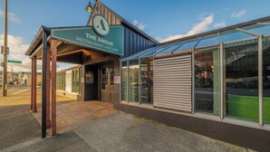 A restaurant named 'The Angus' with a covered entrance and a glass facade.