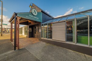 Un restaurante llamado 'The Angus' con una entrada cubierta y fachada de vidrio.