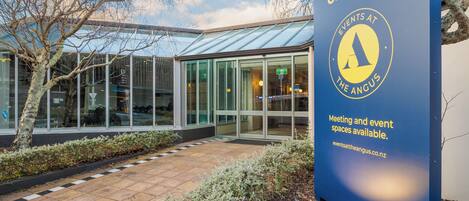 A building with a large blue sign advertising events at The Angus.
