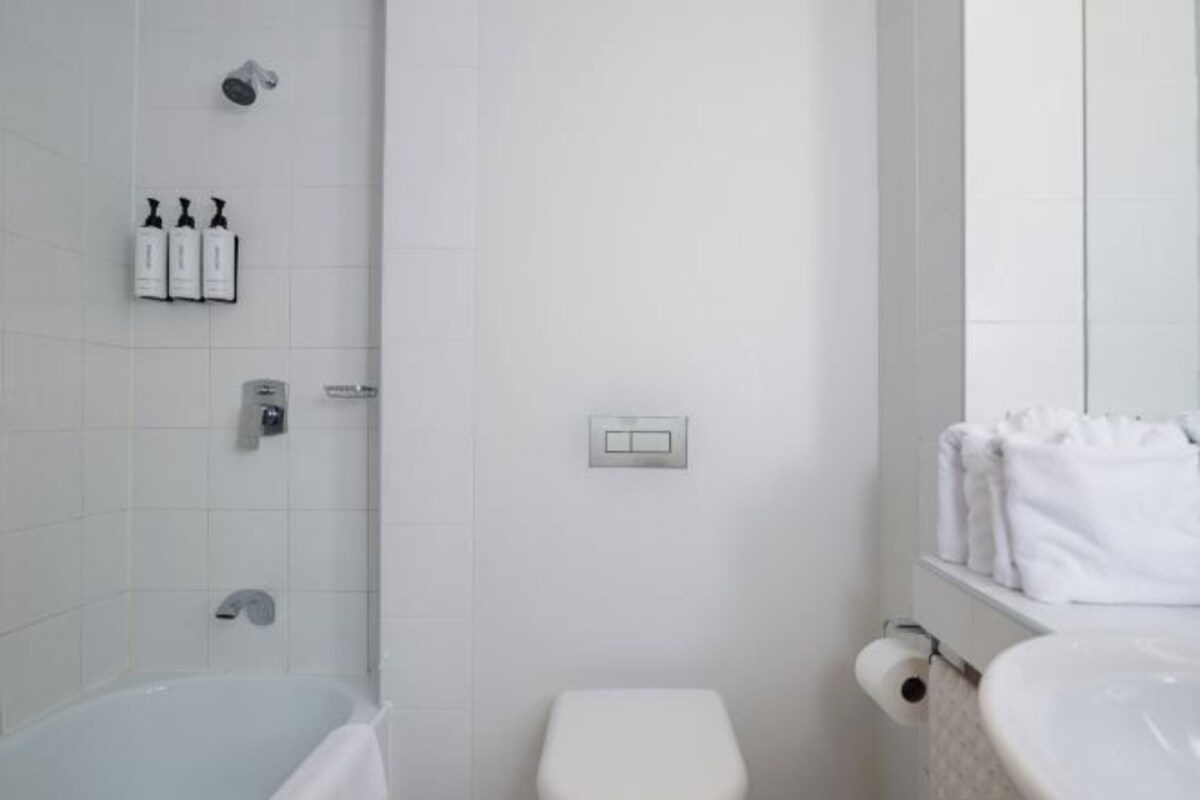Ein Badezimmer mit Badewanne, Toilette und Handtuchhalter.