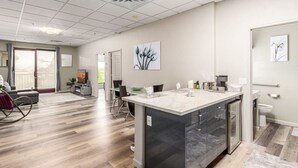 Una habitación de hotel moderna con una isla grande, un baño separado y un comedor con vistas.