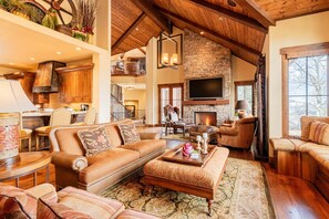 A spacious living area with a fireplace, wooden furniture, and a stone accent wall.
