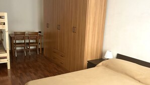 A room with a bed, a wooden wardrobe, a desk with chairs, and a nightstand with a lamp. - A38 - Ancona, comfortable two-room apartment in the historic center (Ancona)