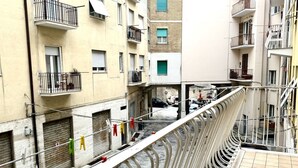 A multi-story building with balconies, a narrow street, and a metal railing. - A38 - Ancona, comfortable two-room apartment in the historic center (Ancona)