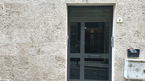 A building facade with a textured wall, a door with a handle, and a mailbox. - A38 - Ancona, comfortable two-room apartment in the historic center (Ancona)