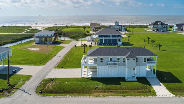 Een woongebied aan de kust met huizen, een pad en uitzicht op de oceaan.