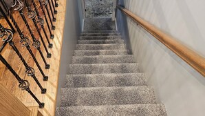 A carpeted staircase with a wooden handrail and metal balusters. - Luxurious Amenities at Zoey's House in Heart of Olivette (Olivette)