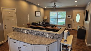 A kitchen with granite countertops, a built-in island, and a dining area with a table and chairs. - Luxurious Amenities at Zoey's House in Heart of Olivette (Olivette)