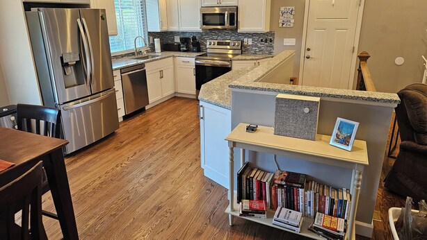 A modern kitchen with white cabinets, stainless steel appliances, and a granite countertop. - Luxurious Amenities at Zoey's House in Heart of Olivette (Olivette)