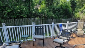 An outdoor deck with multiple chairs and a table, surrounded by a white fence. - Luxurious Amenities at Zoey's House in Heart of Olivette (Olivette)