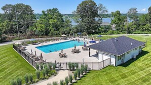 A house with a swimming pool, surrounded by a fenced patio area with outdoor furniture and a view of a lake. - Villa Como at Interlaken |Short Walk to Beach |Pool |Gas Fireplace |Ski at Alpine or Grand Geneva (Lake Geneva)