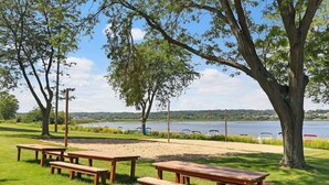 A picnic area with wooden benches and tables, surrounded by trees and a lake view. - Villa Como at Interlaken |Short Walk to Beach |Pool |Gas Fireplace |Ski at Alpine or Grand Geneva (Lake Geneva)