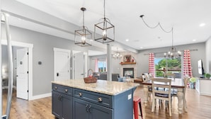 A spacious kitchen with granite countertops, a central island, and pendant lighting. - Scenic Lake Views, Inviting Community Pool, Free Daily Attraction Tickets & Air Hockey! (Branson)