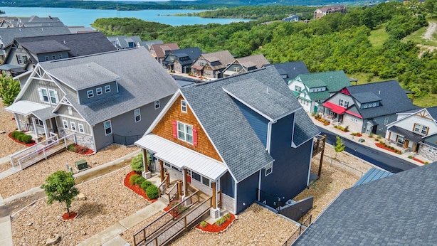 A residential area with houses featuring gabled roofs and a mix of siding materials. - Scenic Lake Views, Inviting Community Pool, Free Daily Attraction Tickets & Air Hockey! (Branson)