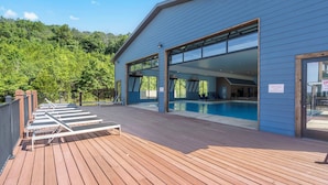 A modern building with a pool area, large glass doors, and a wooden deck. - Scenic Lake Views, Inviting Community Pool, Free Daily Attraction Tickets & Air Hockey! (Branson)