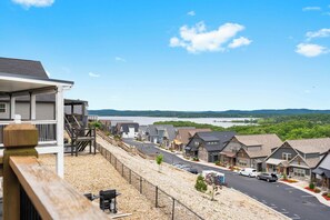 A residential area with houses, a road, and a body of water in the background.
