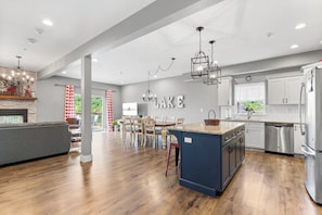 A spacious kitchen with a central island, modern appliances, and a view to the outdoors.